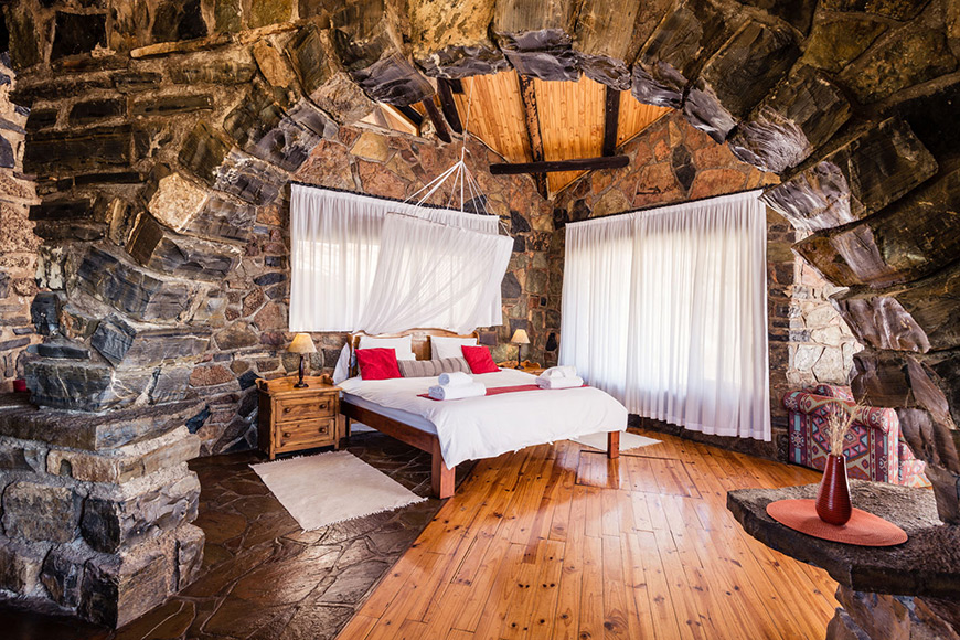 Rock chalet inside with bed and mosquito net