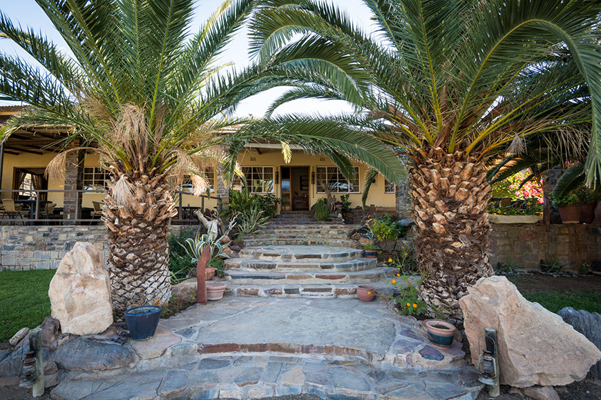Entrance of Zebra River Lodge with palm trees