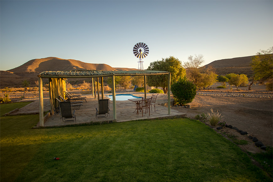 Swimming pool with loungers in shade area at Zebra River Lodge and Tsaris mountains in background