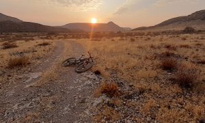 Sunrise with Moutainbike on trail with Tsaris mountains in background at Zebra River Lodge