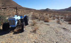 Henk's broken little blue tractor in front of trail to Gail's Cave